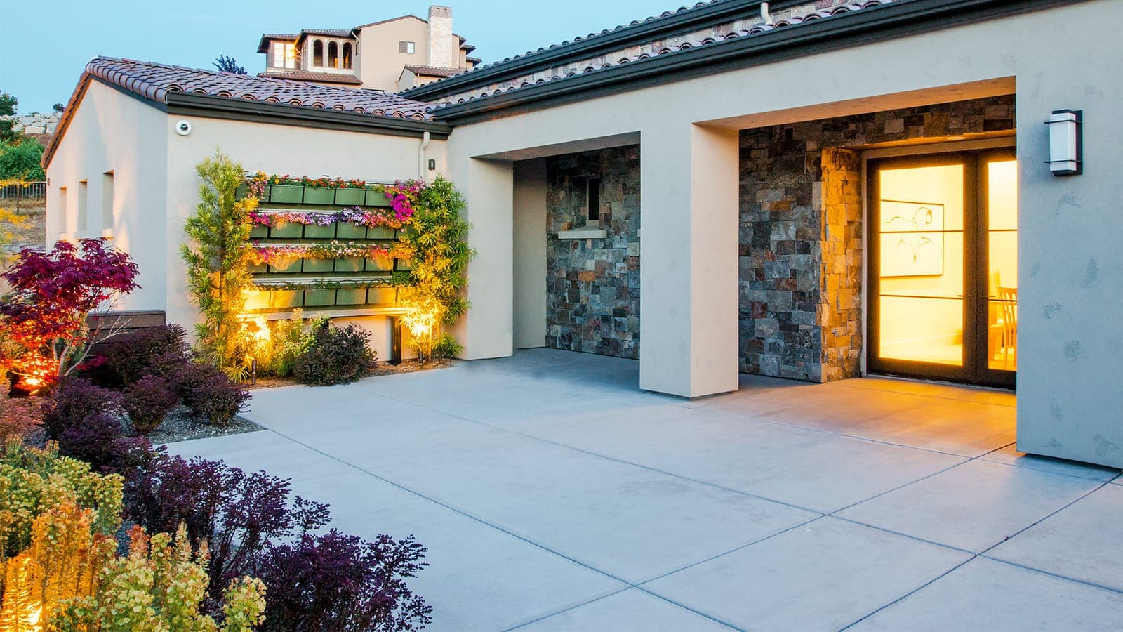 Courtyard with a living green wall and warm evening lighting