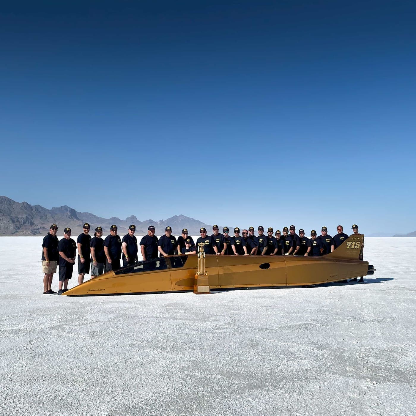 The Speed Demon 715 team lined up behind the streamliner on the Bonneville Salt Flats
